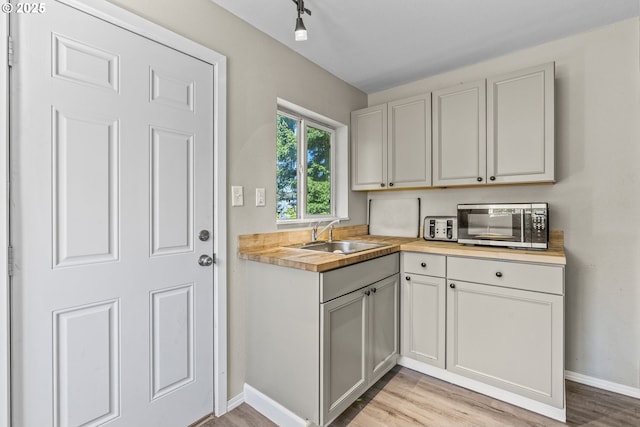 767 32nd Ave, Longview, WA 98632 - kitchen with stainless steel microwave, a sink, light wood finished floors, baseboards, and butcher block counters