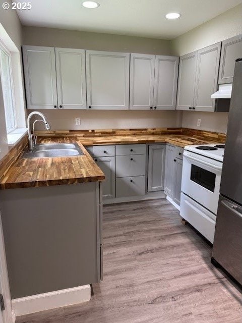 767 32nd Ave, Longview, WA 98632 - kitchen featuring butcher block counters, electric range, freestanding refrigerator, a sink, and recessed lighting
