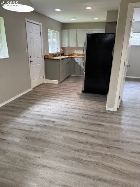 767 32nd Ave, Longview, WA 98632 - kitchen with freestanding refrigerator, baseboards, a sink, light wood-style floors, and recessed lighting