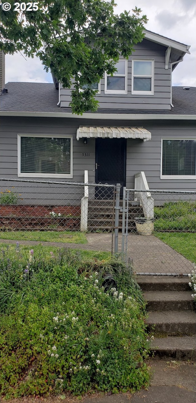view of front of property featuring fence and roof with shingles