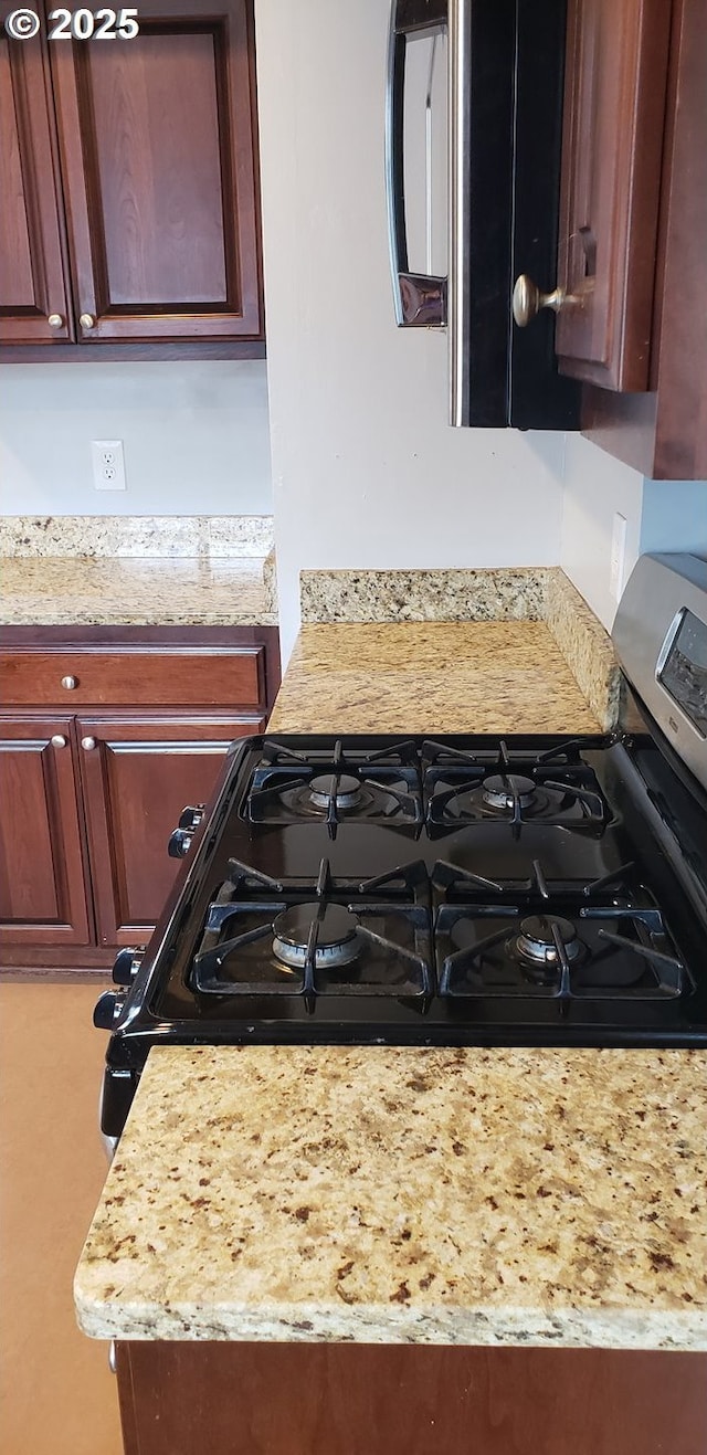kitchen view of light stone counters and gas range