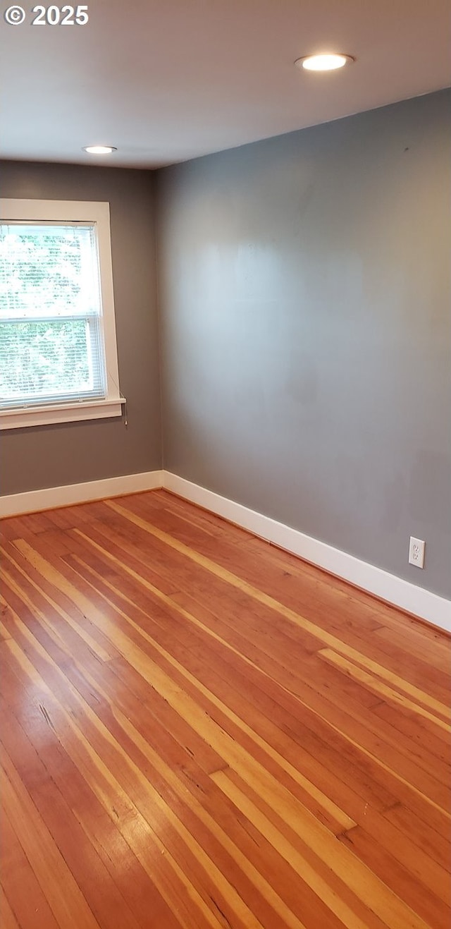 unfurnished room with light wood finished floors, baseboards, and recessed lighting