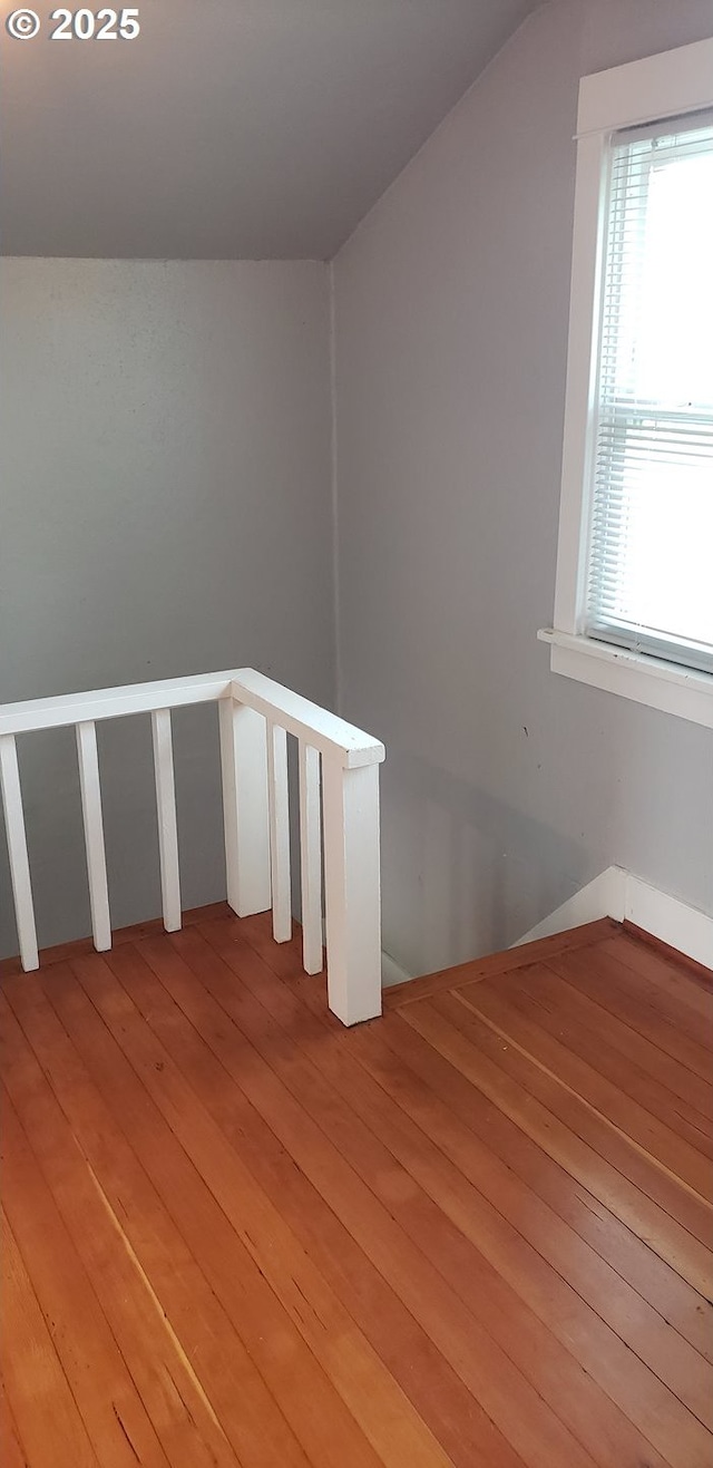 stairway with hardwood / wood-style flooring and lofted ceiling