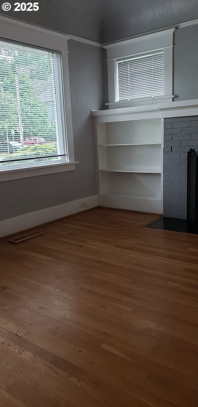 unfurnished living room featuring wood finished floors and baseboards