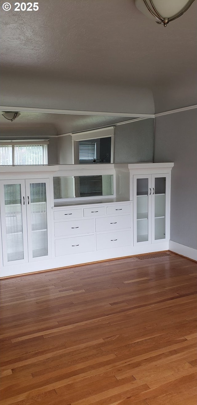 unfurnished living room with wood finished floors and baseboards