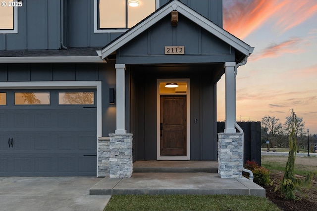 2112 NW 17th Pl, Battle Ground, WA 98604 - exterior entry at dusk with board and batten siding, an attached garage, covered porch, and concrete driveway