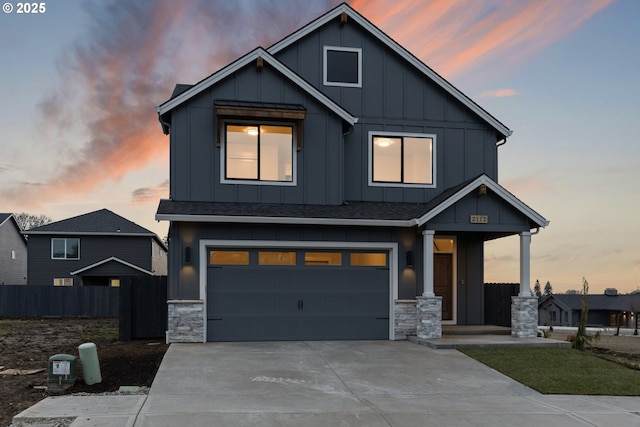 2112 NW 17th Pl, Battle Ground, WA 98604 - view of front facade featuring board and batten siding, a garage, driveway, stone siding, and roof with shingles