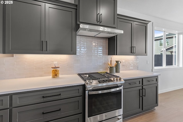 2112 NW 17th Pl, Battle Ground, WA 98604 - kitchen featuring stainless steel range with gas cooktop, under cabinet range hood, light countertops, gray cabinets, and light wood-type flooring
