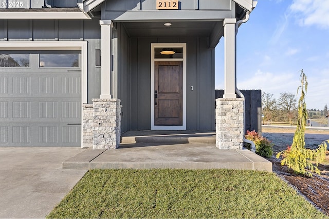 2112 NW 17th Pl, Battle Ground, WA 98604 - doorway to property with board and batten siding, an attached garage, a porch, and stone siding