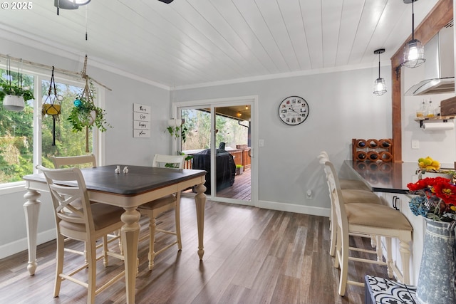 dining space featuring ornamental molding, wooden ceiling, baseboards, and light wood finished floors