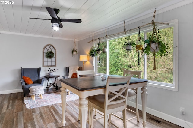 dining space featuring ornamental molding, visible vents, baseboards, and wood finished floors