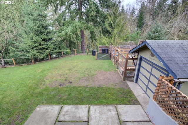 view of yard with a fenced backyard, a storage unit, and an outbuilding