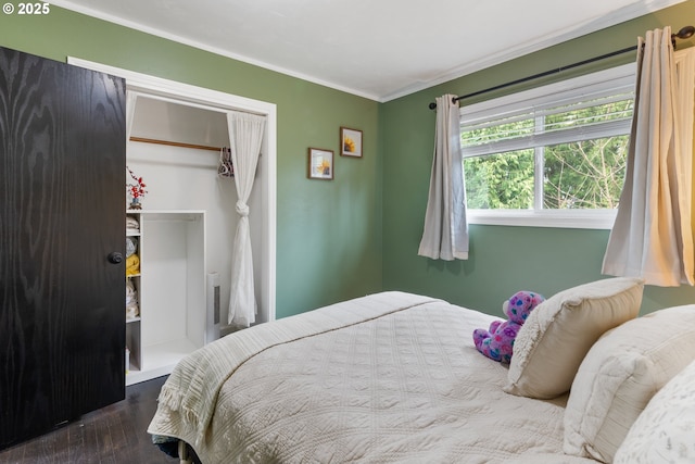 bedroom featuring a closet, wood finished floors, and crown molding