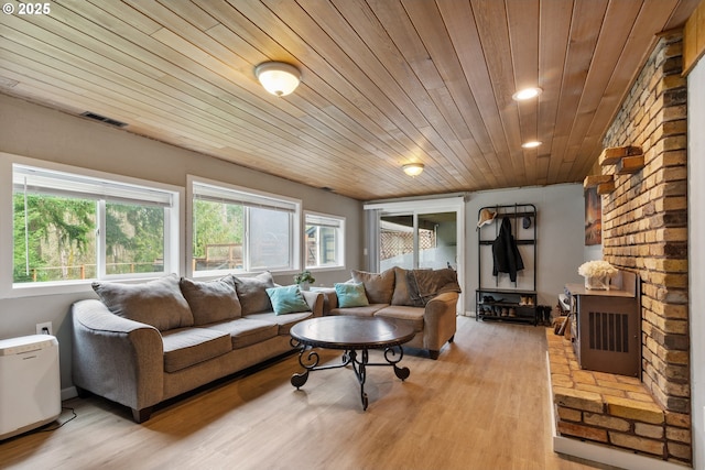 living room with wood ceiling, visible vents, light wood finished floors, and a healthy amount of sunlight