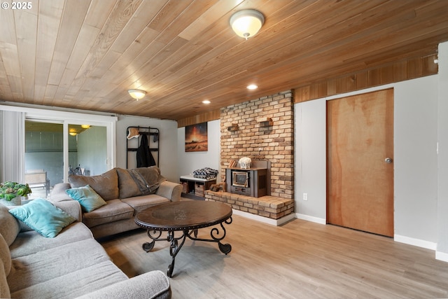 living area with light wood finished floors, baseboards, wood ceiling, a wood stove, and recessed lighting