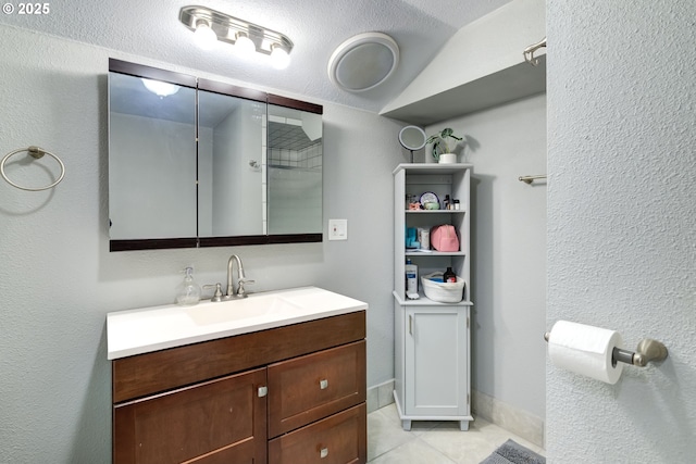 bathroom with baseboards, vanity, and tile patterned floors