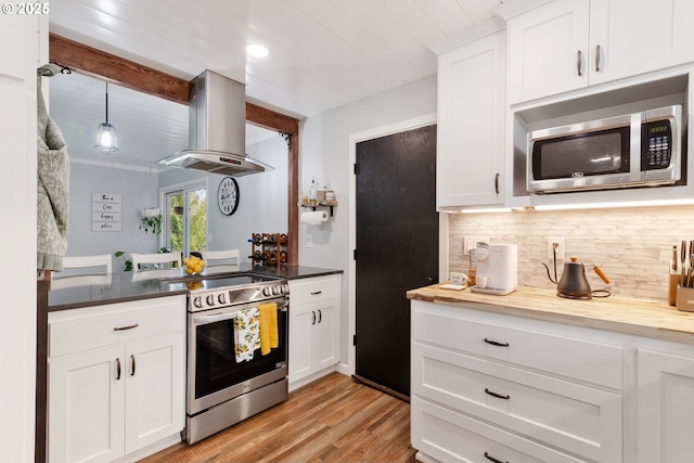 kitchen with island range hood, stainless steel appliances, white cabinetry, light wood-type flooring, and backsplash