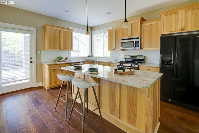 7010 N Kellogg St, Portland, OR 97203 - kitchen featuring appliances with stainless steel finishes, light brown cabinetry, dark wood-type flooring, a center island, and recessed lighting