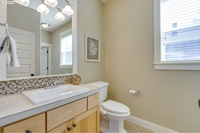 7010 N Kellogg St, Portland, OR 97203 - bathroom with toilet, vanity, baseboards, tile patterned flooring, and backsplash