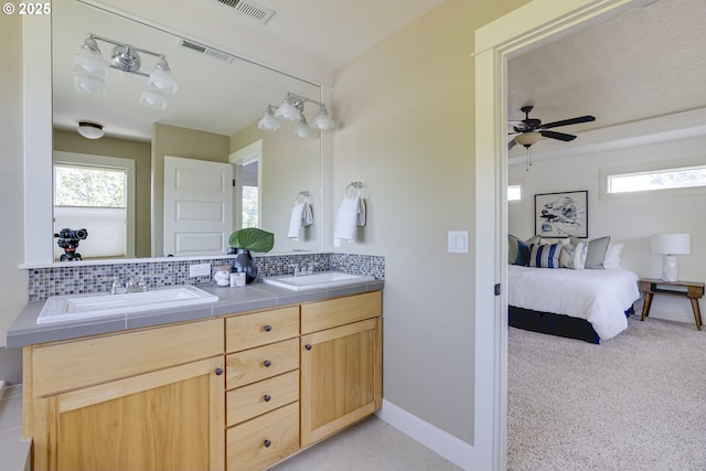 7010 N Kellogg St, Portland, OR 97203 - bathroom with double vanity, tasteful backsplash, healthy amount of natural light, and connected bathroom
