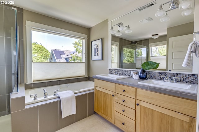 7010 N Kellogg St, Portland, OR 97203 - full bathroom featuring plenty of natural light, double vanity, a garden tub, and tasteful backsplash
