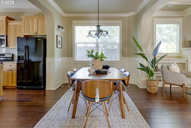 7010 N Kellogg St, Portland, OR 97203 - dining space featuring a wainscoted wall, arched walkways, dark wood-type flooring, crown molding, and a decorative wall