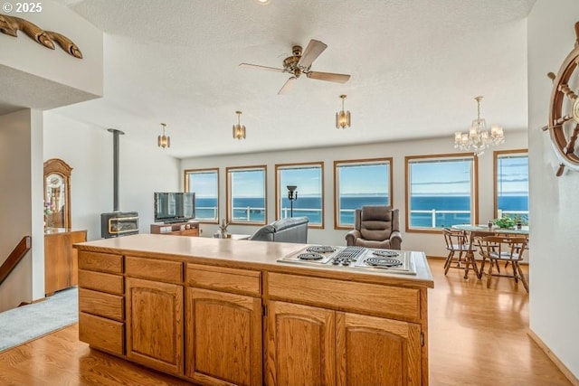 461 Terrace Dr, Rockaway Beach, OR 97136 - kitchen featuring stainless steel electric stovetop, plenty of natural light, light wood-type flooring, a ceiling fan, and a textured ceiling