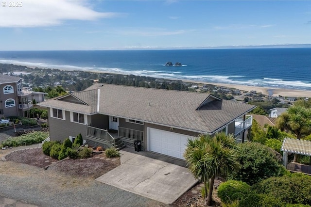 461 Terrace Dr, Rockaway Beach, OR 97136 - view of front of property featuring an attached garage, a shingled roof, driveway, and a water view
