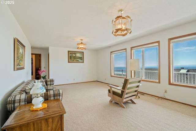461 Terrace Dr, Rockaway Beach, OR 97136 - living area featuring carpet flooring, baseboards, a water view, and a chandelier