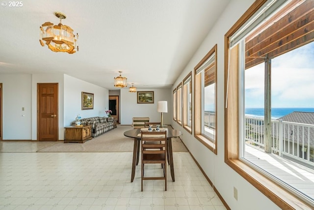 461 Terrace Dr, Rockaway Beach, OR 97136 - dining area with a chandelier, light floors, baseboards, and a water view