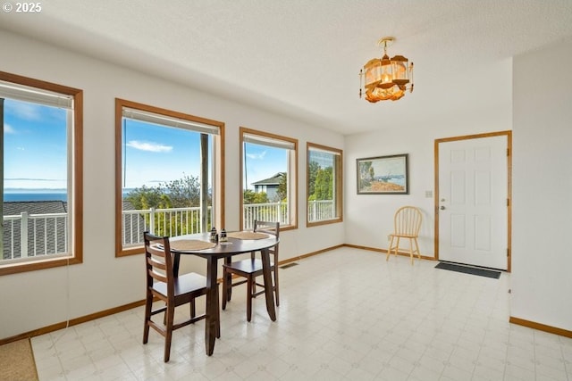 461 Terrace Dr, Rockaway Beach, OR 97136 - dining area with baseboards and a chandelier
