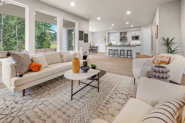 living area with light wood-type flooring and recessed lighting