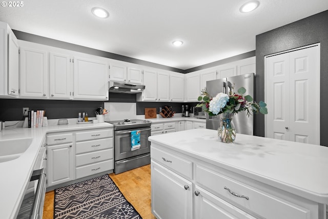 kitchen featuring stainless steel appliances, white cabinetry, and sink