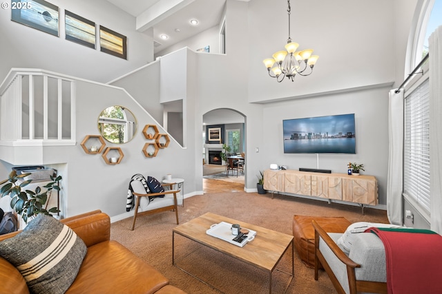 carpeted living room with an inviting chandelier and a high ceiling