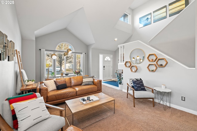 living room with plenty of natural light, high vaulted ceiling, and carpet