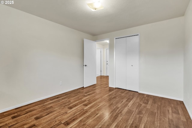 unfurnished bedroom with wood-type flooring and a closet