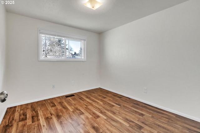 unfurnished room with hardwood / wood-style flooring