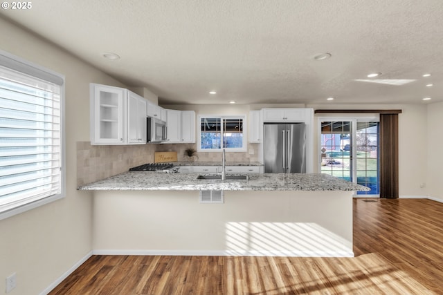 kitchen featuring white cabinetry, sink, stainless steel appliances, and kitchen peninsula