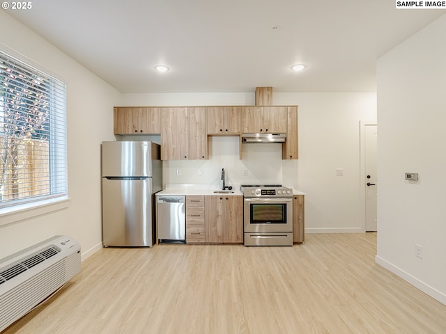 kitchen with appliances with stainless steel finishes, light brown cabinetry, and light hardwood / wood-style flooring