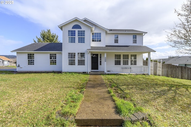 traditional-style home with covered porch, a shingled roof, a front yard, and fence