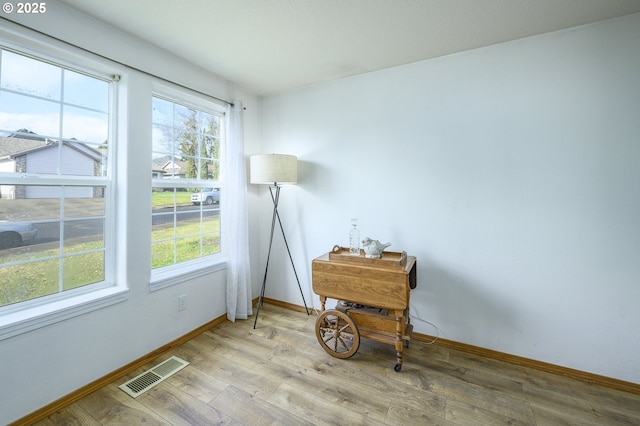 interior space featuring baseboards, visible vents, and wood finished floors