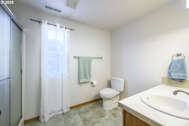 bathroom with toilet, a shower stall, visible vents, and baseboards