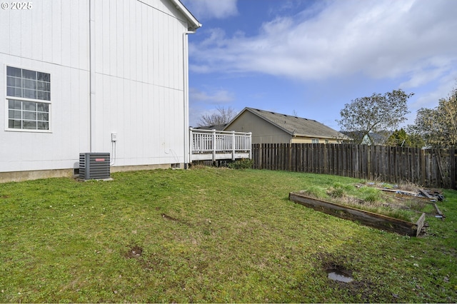 view of yard with a vegetable garden, fence, and central air condition unit