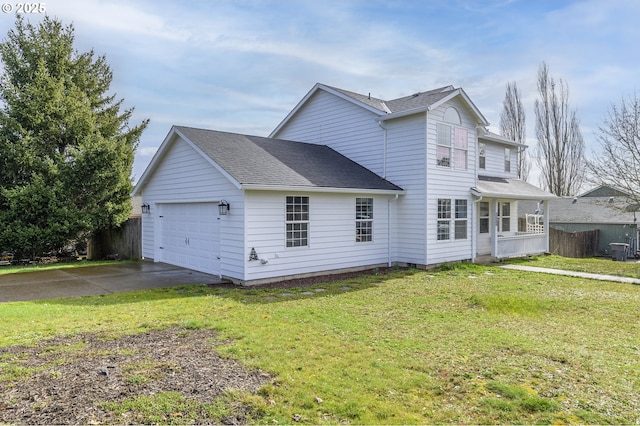 exterior space with roof with shingles, a lawn, fence, a garage, and driveway