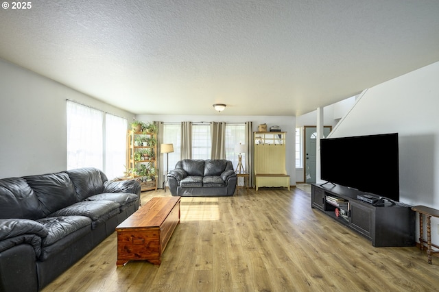 living area with light wood finished floors and a textured ceiling