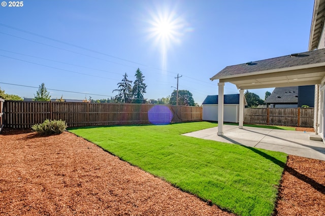 view of yard with a patio area, a fenced backyard, a storage shed, and an outbuilding