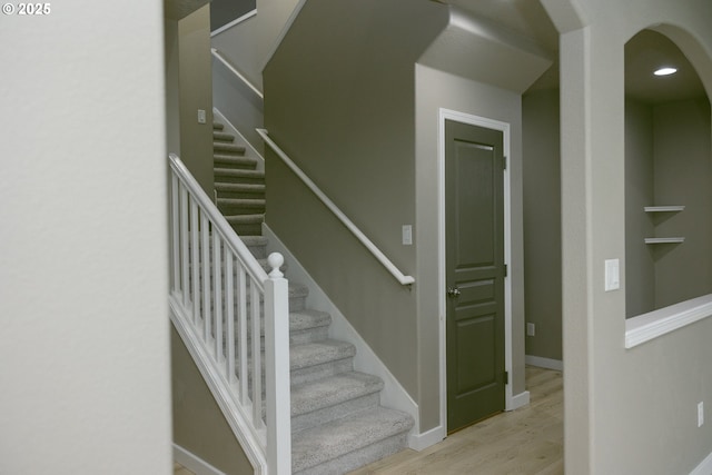 stairway with recessed lighting, baseboards, and wood finished floors