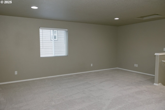 empty room featuring carpet floors, baseboards, a textured ceiling, and recessed lighting