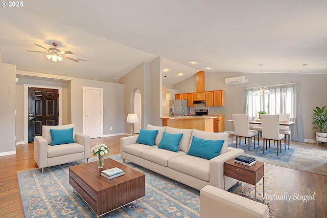 15807 NE 48th Cir, Vancouver, WA 98682 - living room with vaulted ceiling, light wood-style flooring, ceiling fan, arched walkways, and a chandelier