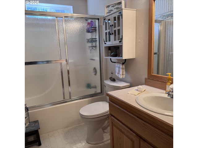 bathroom with vanity, combined bath / shower with glass door, tile patterned floors, and toilet